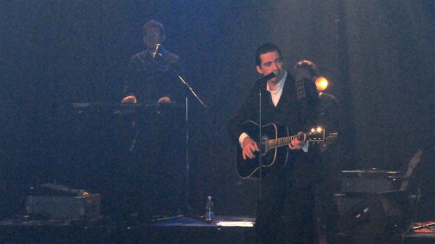 Une salle comble salue l'homme en noir