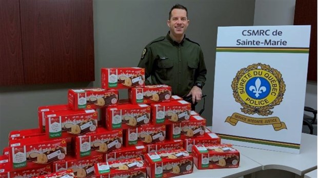 Un policier de la Sûreté du Québec remet 100 bûches de Noël à des familles défavorisées
